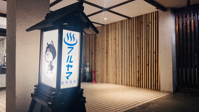 灯りに包まれた入口の行灯看板。看板犬モチーフのロゴが描かれています